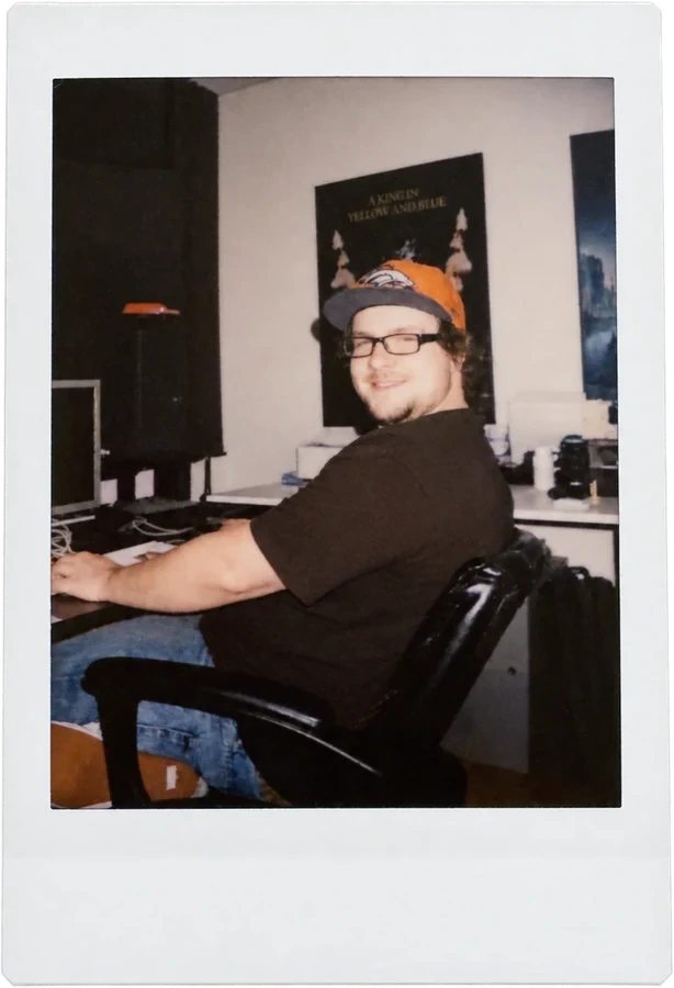 An editor at his desk, turning to the camera
